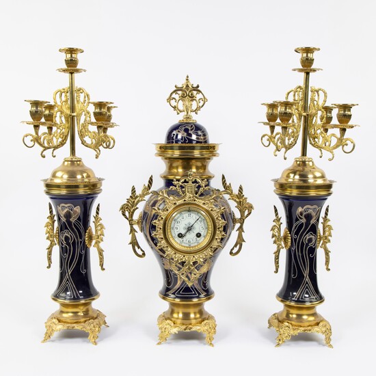 Three piece faience garnish decorated with stylized whiplash motifs and gilt brass, candlesticks with 5 light points, ca 1900