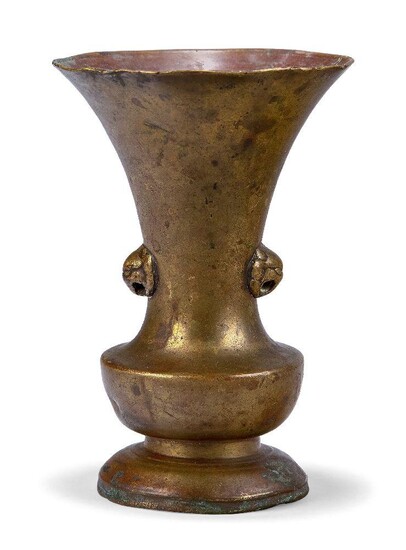 A Chinese bronze vase, 18th century, the long flared neck cast with lion mask handles above spreading circular foot, 14.5cm high