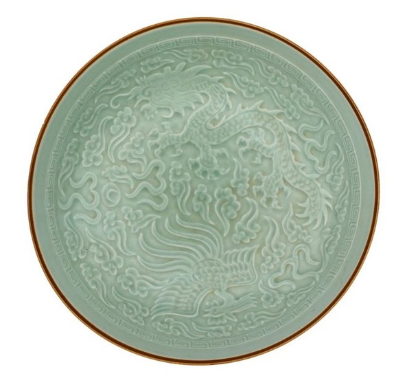 A Chinese celadon-glazed dish, relief decorated with a...
