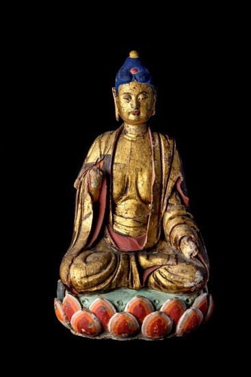 A Chinese gilt and painted stucco figure of Buddha, Ming dynasty with later pigment, the rounded squarish face with downcast eyes and thick lips, hair covered in blue pigment atop a jewel, forehead adorned with a red urna, seated in ardha padmasana...