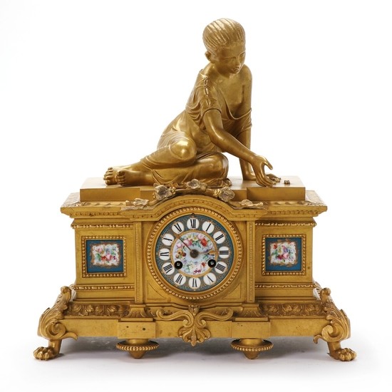 A French gilt bronze figural mantel clock. Late 19th century. H. 33 cm. W. 34 cm. D. 18 cm.