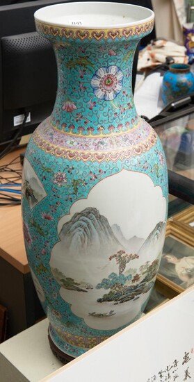 A LARGE CHINESE FAMILLE ROSE PORCELAIN VASE WITH TURQUOISE GROUND DEPICITING A LANDSCAPE SCENE ON A WOODEN BASE