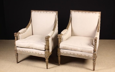 A Pair of Louis XVI Style Carved & Painted Armchairs. The square upholstered backs, down-swept sides