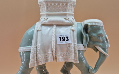 A ROYAL WORCESTER GLAZED PARIAN CELADON COLOURED ELEPHANT CAPARISSONED WITH A WHITE HOWDAH. H