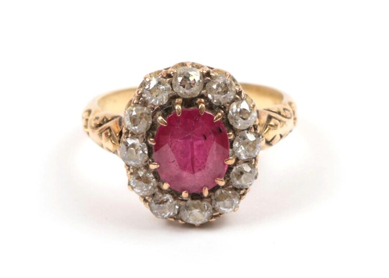 A Red Stone and Diamond Cluster Ring, the oval cut red stone within a border of old cut...