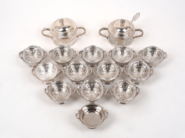 A matched pair of Buccellati silver mounted glass sugar/jam bowls, signed Gianmaria Buccellati, designed with reeded crossover patterned twin handles to mounts, the pull off covers with conforming finials, one glass insert probably a replacement...