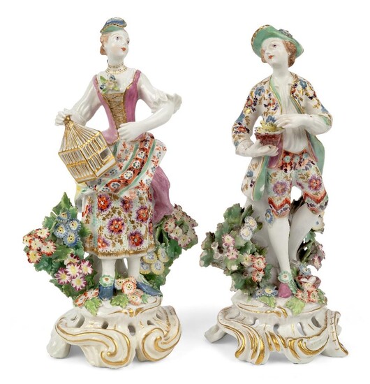 A pair of Bow porcelain figures emblematic of Liberty and Matrimony, c.1765, iron red anchor and dagger marks, each modelled standing before bocage, Liberty as a gentleman holding a nest of birds, Matrimony as a lady holding a birdcage, on pierced...