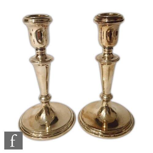 A pair of hallmarked silver candlesticks of plain form, circ...