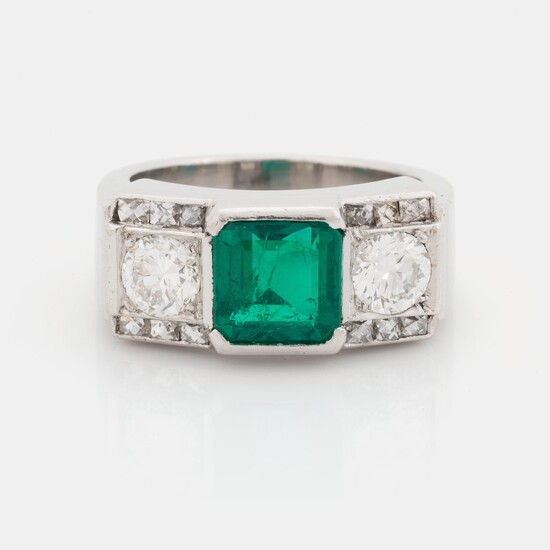 A platinum ring set with a step-cut emerald and round brilliant- and step-cut diamonds