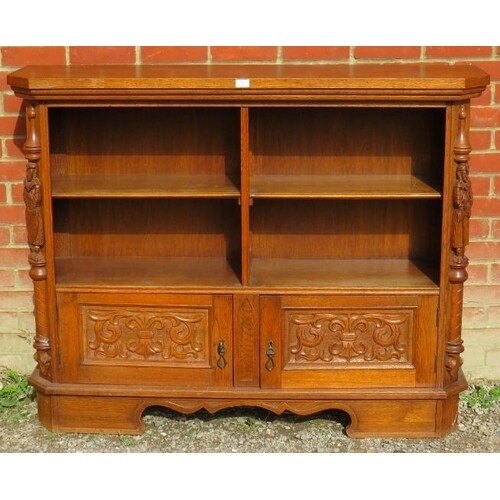 A vintage carved oak low open bookcase comprising four shelv...