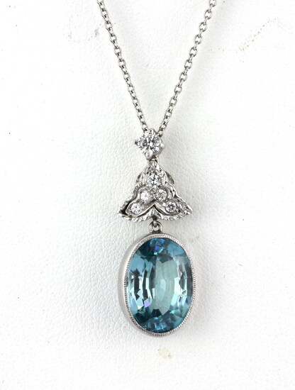 A white metal (tested high carat gold) pendant set with an old oval cut blue stone and diamonds on a 950 platinum chain.