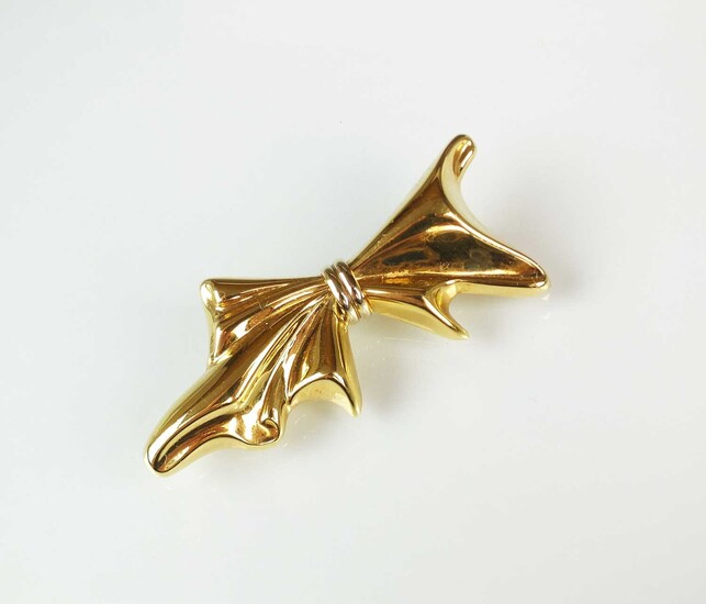 A yellow metal stylised bow brooch