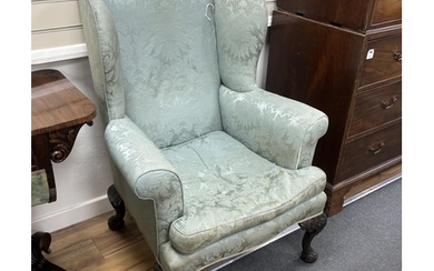 An early 20th century George III style upholstered wing armc...
