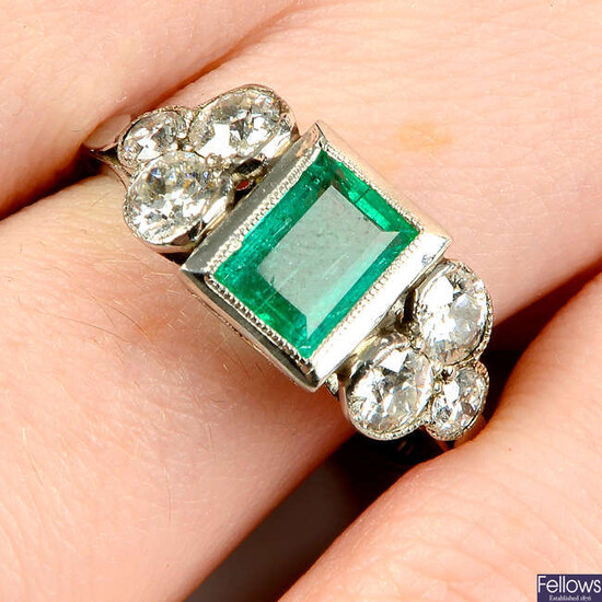 An emerald and circular-cut diamond ring.