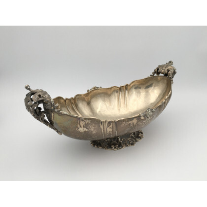 Centrotavola in argento con bordo mistilineo, anse traforate e decorate a motivi fogliati (gr 1300 ca) (lievi difetti)