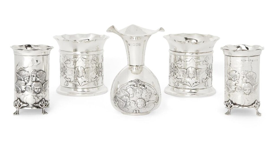 Five silver putti-decorated Victorian and Edwardian vases comprising: a pair of cylindrical Victorian examples with shaped rims, London, 1897, William Comyns & Sons, 9.6cm high; a pair of smaller cylindrical Edwardian examples raised on four...