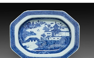 GRAND PLAT CREUX en porcelaine et émaux bleu sous couverte, de forme octogonale, à décor de paysage lacustre animé de pagodes, la...
