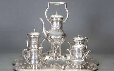 Large tea and coffee set in 916 Spanish silver, c.1920. Relief decoration of vine leaves and grapes. Set composed by: big rectangular tray with handles, samovar, teapot, coffee pot, milk pot, sugar bowl. Associated tweezers. Engraved initials. Weight: 7