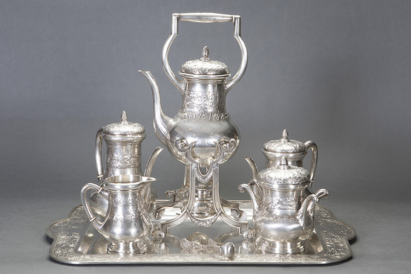 Large tea and coffee set in 916 Spanish silver, c.1920. Relief decoration of vine leaves and grapes. Set composed by: big rectangular tray with handles, samovar, teapot, coffee pot, milk pot, sugar bowl. Associated tweezers. Engraved initials. Weight: 7
