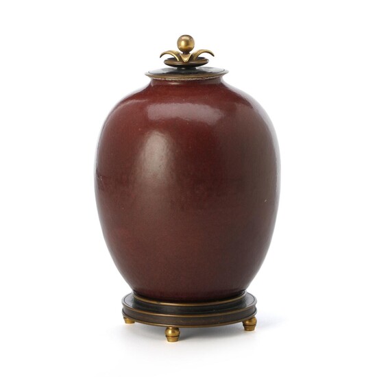 SOLD. Kresten Bloch, Knud Andersen: A round stoneware lid jar decorated with oxblood glaze. Lid and base of patinated and partly gilded bronze. H. 25.5 cm. – Bruun Rasmussen Auctioneers of Fine Art