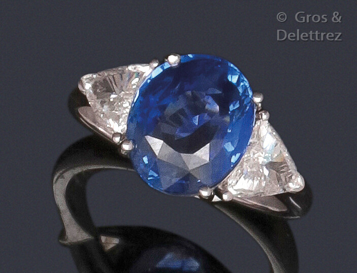 White gold ring set with an oval facetted sapphire set with troika diamonds. Total weight of the diamants : about 0.70 carat. Weight of saphir : 4.07 carats. Origine : Sri Lanka. It is accompanied by a certificate from the GIA (American gemmological...