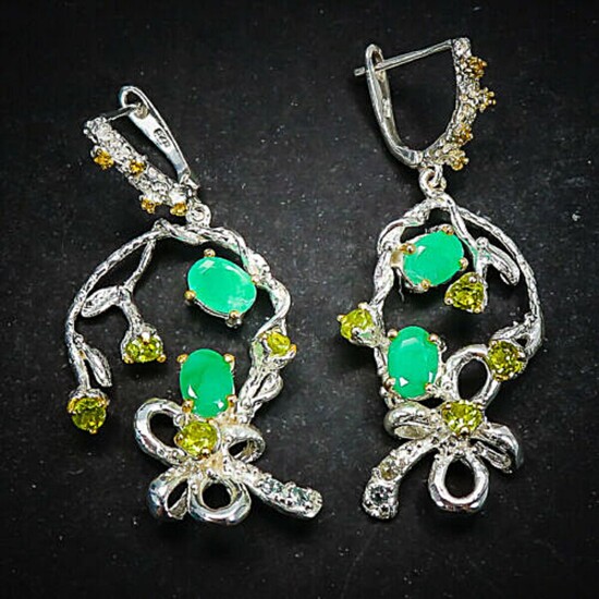 a pair of emerald and peridot ear pendants each set with numerous oval and circular-cut emeralds and peridots, mounted in rhodium plated sterling silver.