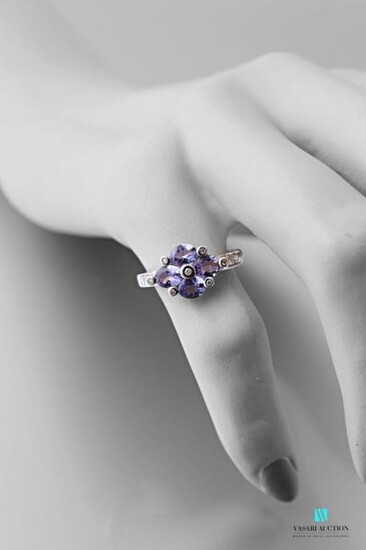 750 thousandths white gold ring set with four oval-shaped tanzanites interspersed and shouldered with modern-cut diamonds.