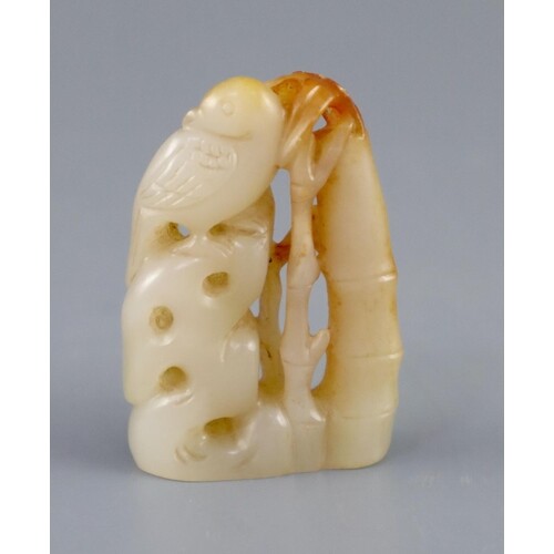 A Chinese pale celadon and russet jade carving of a bird on ...