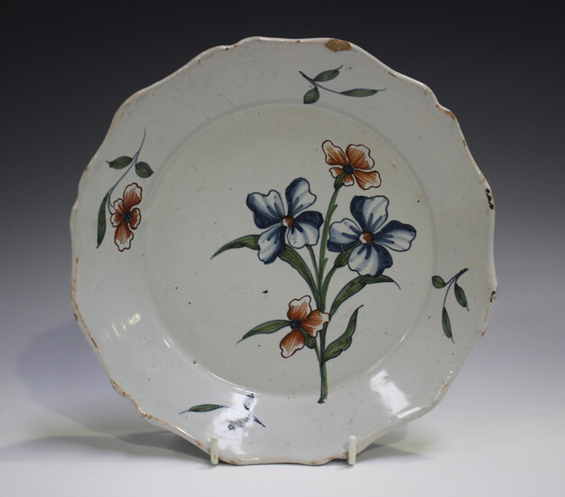 A Delft plate, 18th century, painted in blue, green and red with a floral spray, diameter 22.5cm (sm