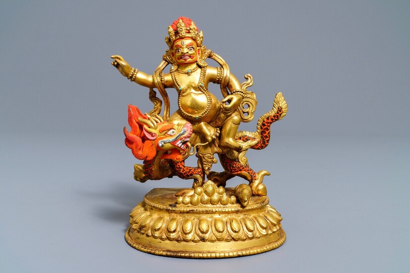 A Sino-Tibetan painted gilt bronze figure of Jambhala on a dragon, 19/20th C.