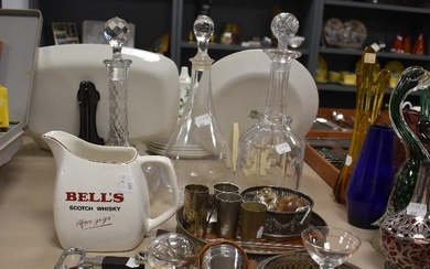 A collection of vintage bar accessories including three glass decanters, measures, bottle openers