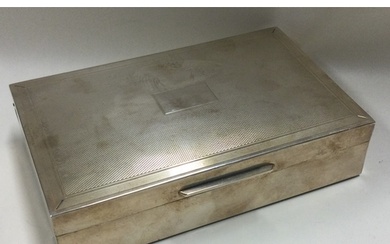 A heavy engine turned silver cigarette box with hinged lid. ...