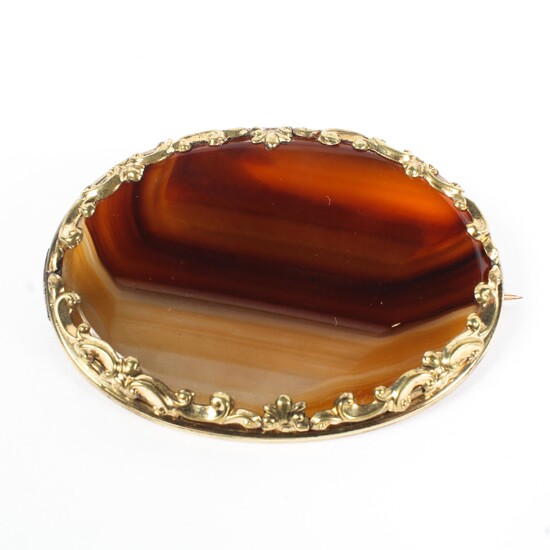 A large yellow metal mounted oval banded agate brooch, 5.5cm x 4cm.