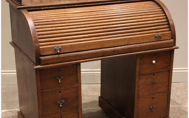 A late Victorian oak roll top desk, with a three quarter spi...