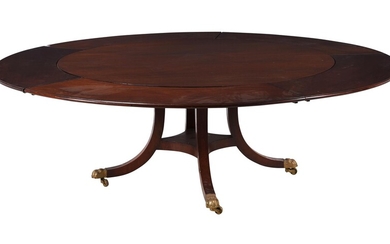 A mahogany circular extending dining table with five detachable leaves