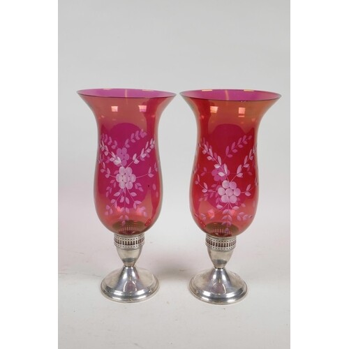 A pair of sterling silver and cranberry glass hurricane cand...