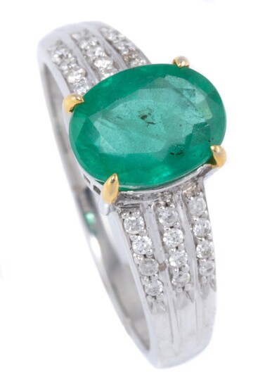 AN EMERALD AND DIAMOND RING; claw set in 10ct white gold with a 1.62ct oval cut emerald above tapering shoulders set with 24 round b...