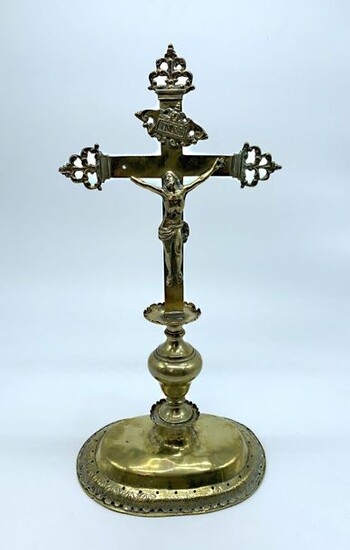 AUTEL CROSS in polished brass resting on an openwork pedestal with acanthus leaves, the upright with bulb and fillets, the ends of the cross decorated with scrolls. 17th century period. Height 44,5 cm. The right hand is missing, small deformations...