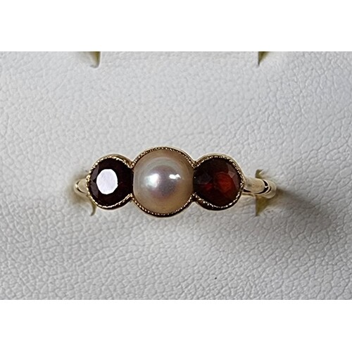 An 18ct gold garnet and pearl three stone ring, Birmingham 1...