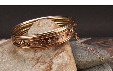 An Edwardian ruby and diamond 9ct gold hinge bangle, set wit...