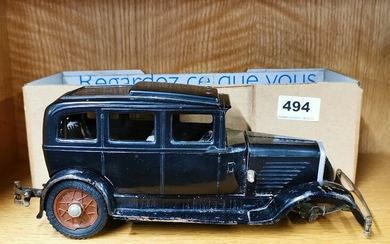 An early (c. 1930) model of a four door saloon car with bakelite body on a pressed metal chassis and clockwork motor with right hand drive