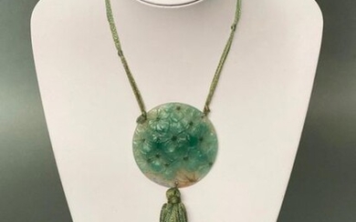 Argy Rousseau (French, 1885 ~ 1953) A pate-de-verre glass circular pendant modelled as flowering hydrangeas on silk cord with tassels. Circa 1920. Pendant height 6.3 cm.