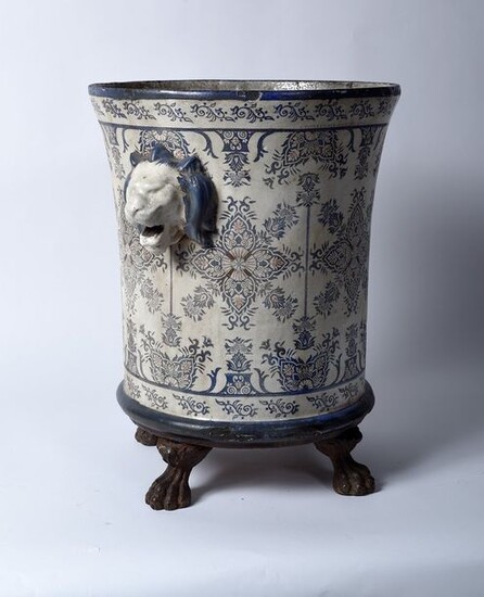 Cast iron vase enamelled in imitation of porcelain in a monochrome of blue and white, taken in lion muffles, it rests on a quadripod claw base, 19th century. This vase is inspired by the models that adorned the Trianon gardens made for Versailles in...