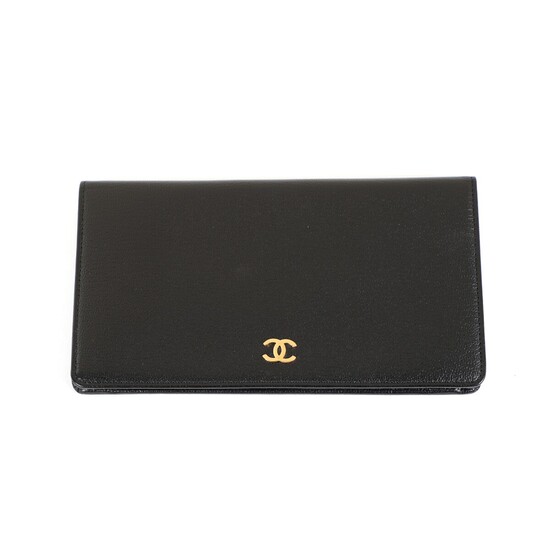 Chanel: A wallet of black leather with gold tone CC_logo, zip pocket, several pockets and card slots, and with black fabric lining.