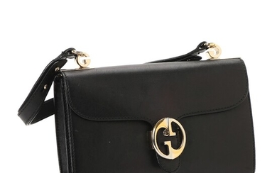 NOT SOLD. Gucci: A bag made of black leather with gold toned hardware and two...