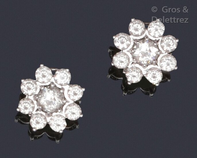 Pair of earrings " Fleurs " in white gold, set with brilliant-cut diamonds, the one in the more important center. Clasp with stem and safety clasp. Total weight of the diamants : about 4.6 carats. P. Brut : 9,6 g.