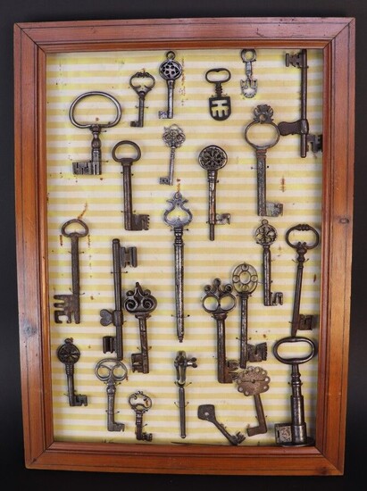 Panel of twenty four keys from the XIVth to the XIXth century. Restorations to some. A small hand vise is attached.