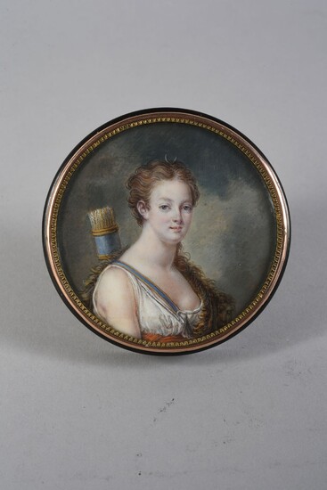 TABATIERE.In black tortoiseshell, round shape, decorated on the lid with a miniature portrait painted on ivory representing Queen Marie-Antoinette as Diana the Huntress, preserved under a curved glass in a gilded copper frame. Containing inside a...
