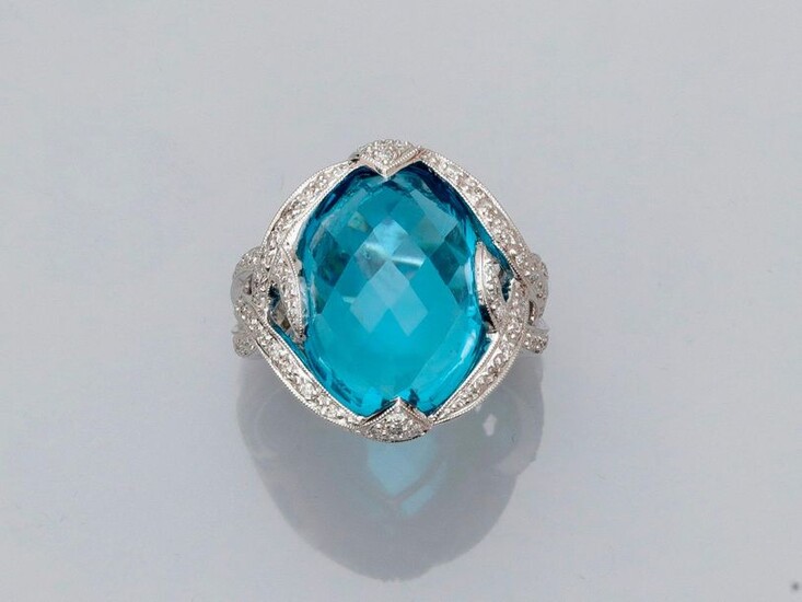 White gold ring, 750 MM, set with a briolette-cut oval blue topaz weighing approximately 18 carats in two diamond ribbons, 18 x 13 mm, size: 55, weight: 12.6gr. rough.