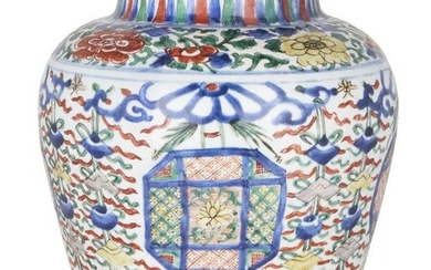 A Chinese porcelain wucai 'Buddhist emblems' jar, 17th century, painted with panels enclosing lotus blossoms surrounded by Buddhist emblems and ribbons, the shoulder with a band of flowering peony blossoms and scrolling leafy stems below a band of...